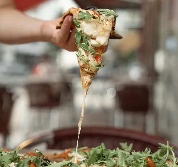 Part de pizza artisanale avec fromage fondu et basilic frais, savoureuse et généreuse
