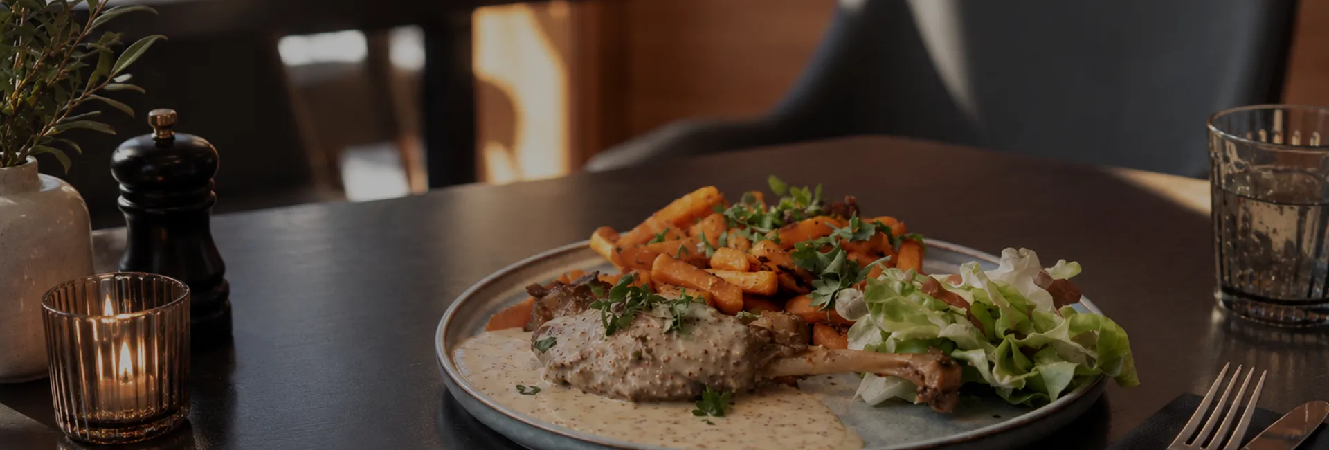 Plat gourmand avec poulet sauce crème, frites et salade fraîche sur table élégante