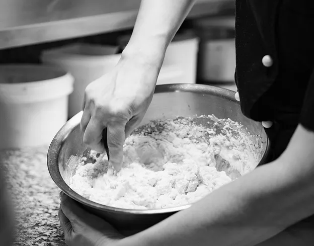 Préparation artisanale de pâte à pizza dans un cadre convivial et familial
